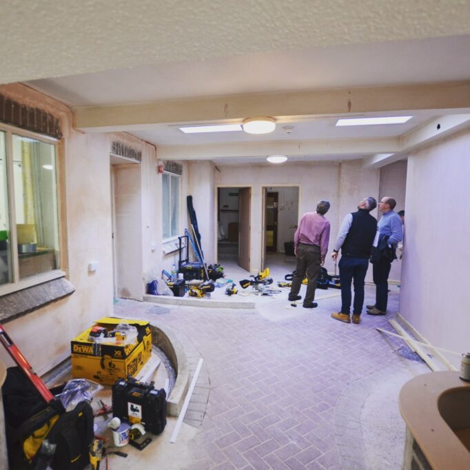 Interior Courtyard under construction in a Pilgrims Friend Retirement Home. Three members of the team looking up checking the lighting.