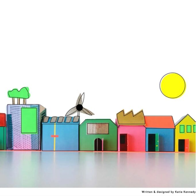 Coloured cardboard houses, in pink, green, blue, yellow and purple. With windows, roof lights and doors. A paper yellow sun on a white sky background.